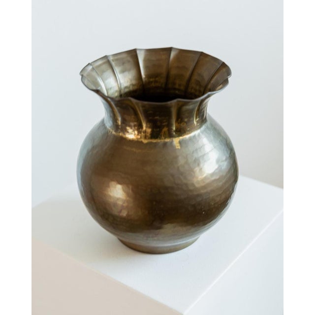 This vintage brass vase from the 1960s features a striking spherical form crowned by an elegant wavy rim, creating a...