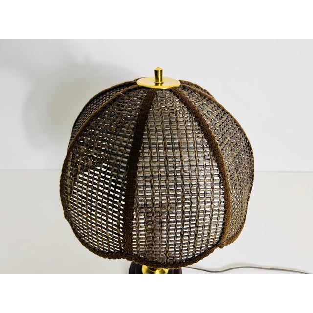 This table lamp, crafted from dark bamboo wood, features a design where the wood opens upward. At the top, a round opal...