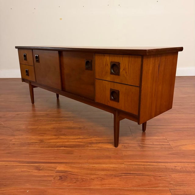 Vintage teak sideboard that features book-matched grain, fantastic afromosia (African teak) round recessed pulls with...