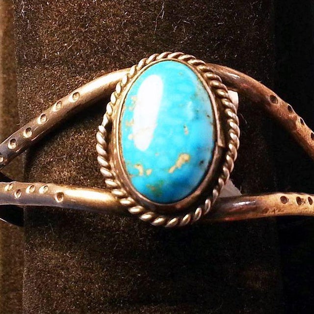 This vintage two-banded silver cuff features a hammer 'dot' pattern and a silver bezel-set turquoise cabochon at its peak....