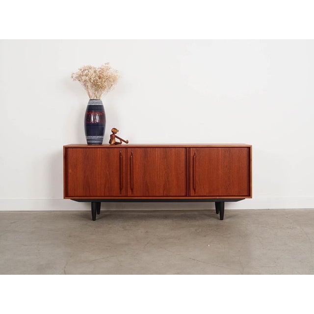 The sideboard was made in the 1960s in Denmark. The structure is covered with teak veneer. The legs are made of solid wood...