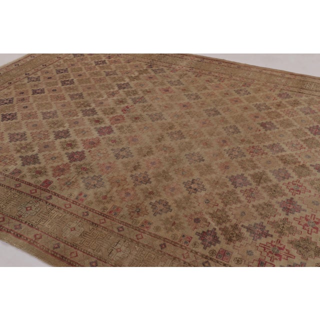 Hand-knotted in wool and believed to originate from East Turkestan circa 1920-1930, this 9x11 antique Khotan rug is a...