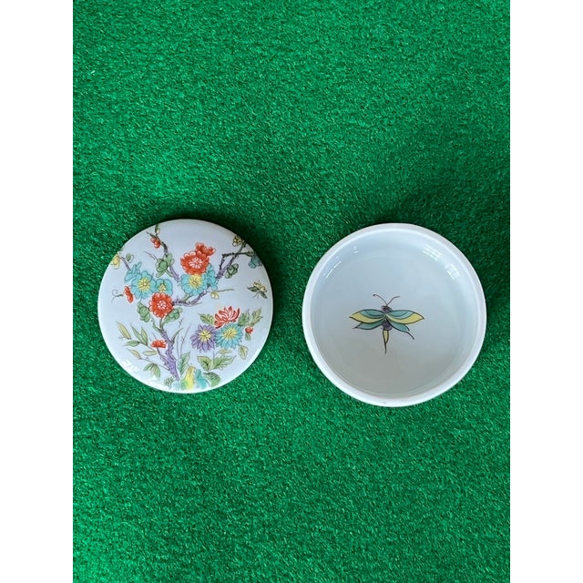 Vintage trinket box from Porcelaine De Paris, France. Cover has branches and flowers, butterflies on the inside surfaces,...