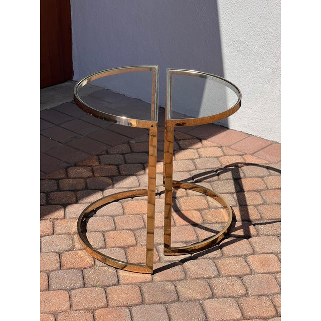 A handsome pair of demi-lune side or end tables with brass frames and glass inserts, circa late 1970s. These are possibly...