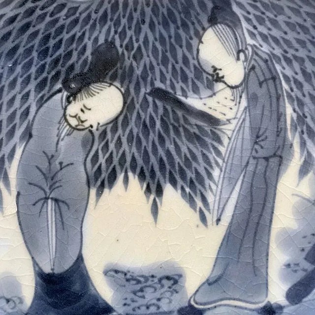 A charming Japanese Arita plate from the Edo Period. Painted in cobalt illustrating a pair of elders or scholars beneath a...