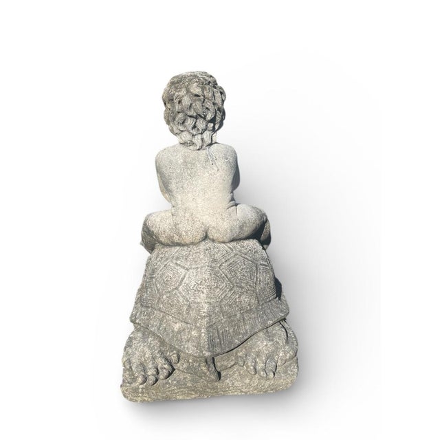 Hand-carved in limestone, this sculptural piece depicts a charming putti (cherub) seated atop a monumental tortoise,...
