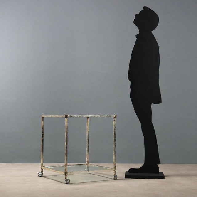 Vintage trolley / coffee table with metal frame and wheels, double square glass top. This piece is attributed to the...