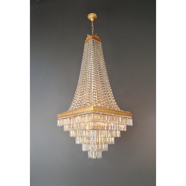 An exceptional set of three impressive crystal chandeliers, defined by their architectural clarity and striking light...