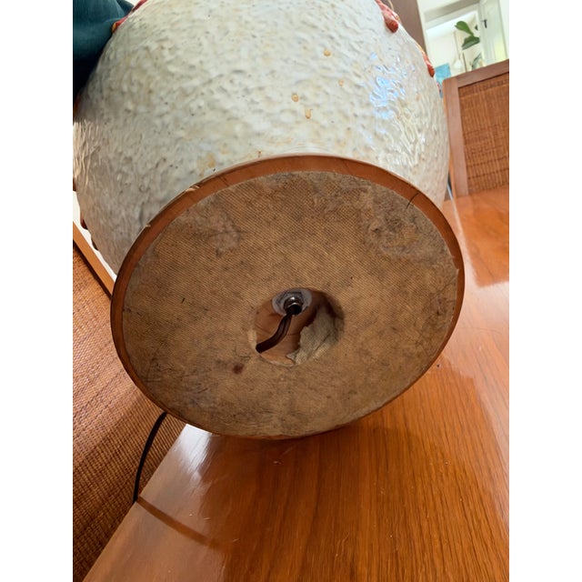 A statement-scale ceramic table lamp from the 1960s–70s. A thick lava drip glaze in orange, saffron yellow, and umber runs...