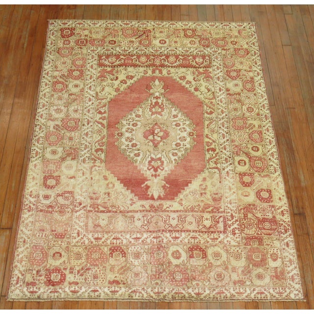 Turkish Oushak rug with a traditional medallion border design in melon red, brown and ivory accents, circa 1920. Measures:...
