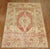 Turkish Oushak rug with a traditional medallion border design in melon red, brown and ivory accents, circa 1920. Measures:...