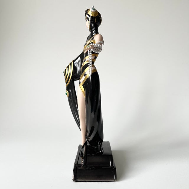 This original House of Erté figurine, titled "Pearls and Emeralds," is a hand-painted fine porcelain collectible produced...
