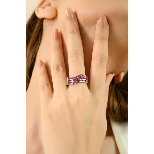 Celebrate modern elegance with this contemporary wave band ring, showcasing 2.02 carats of natural rubies, the radiant...