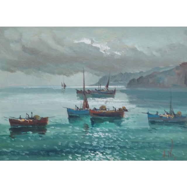 A beautiful circa 1930's Italian oil painting on canvas depicting fishing boats off the coast on a calm sea. The artist...