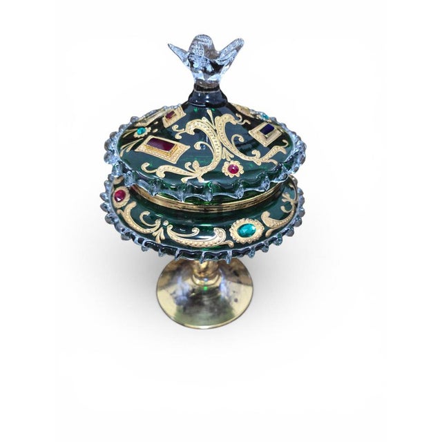 An exquisite Venetian decorative covered bonbonnière or compote, crafted in emerald green blown glass and richly...