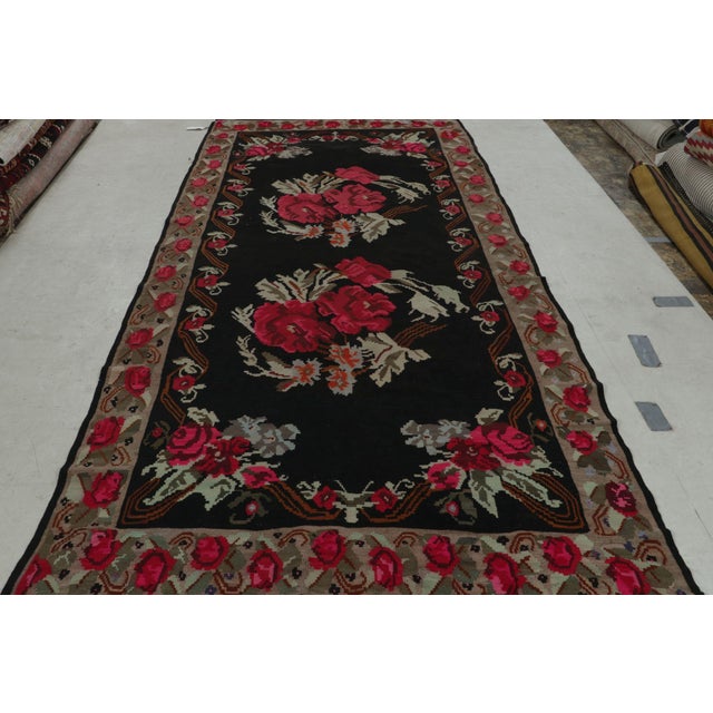 Hand woven in wool originating from Turkey circa 1950-1960, this item is a vintage floral Bessarabian kilim, affording a...