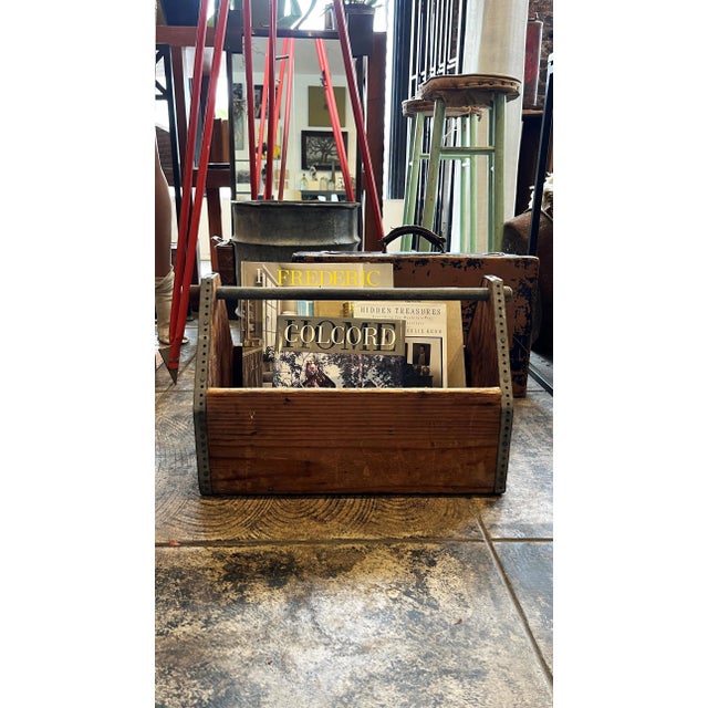 This is a rustic wooden tote with industrial metal detailing along the edge. It would function as a storage container for...