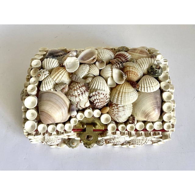 Here is a charming handmade, folk art jewelry box that is decorated with seashells. The piece features a treasure chest...