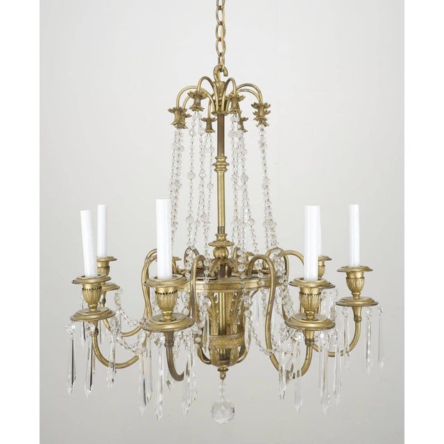 French style chandelier with a brass frame draped in faceted crystal ball swags and spears. The chain is made of steel....