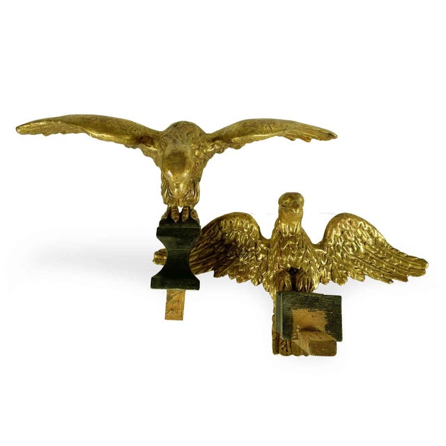 A Pair of Carved and Gilded Wooden Eagles from the mid-1800s, this pair of carved and gilded wooden birds of prey...