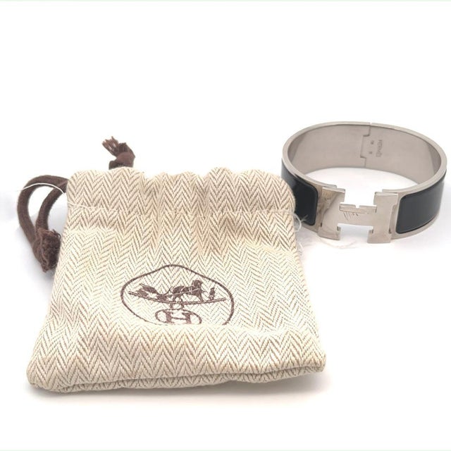 This chic and fashionable bracelet is authentic by Hermes from the Clic Clack Collection. It is silver plated metal with...