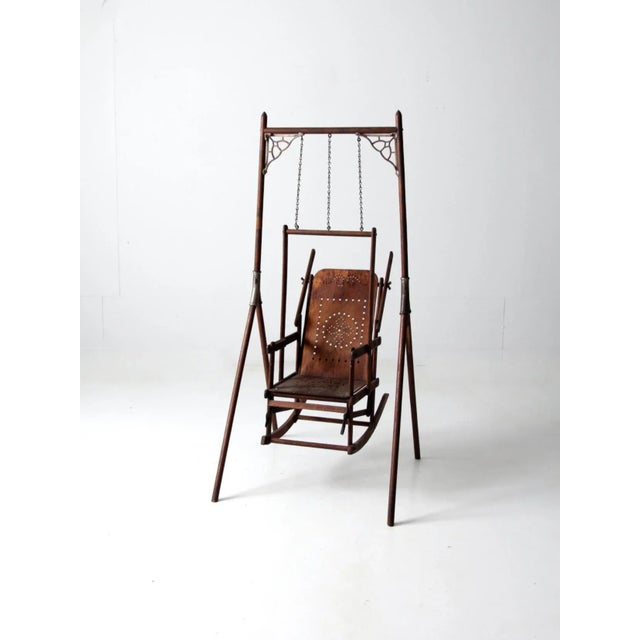 An antique decorative swing chair from the late 19th century, crafted in the Victorian era with a wooden stand and Art...