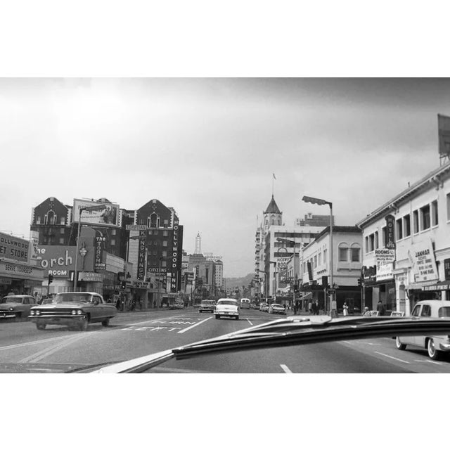 This black-and-white photograph captures the iconic Hollywood Boulevard in the 1960s, offering a snapshot of the bustling...