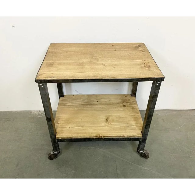 Industrial table from the 1960s. It features an iron construction,a four original wheels and a solid wooden plate. The...