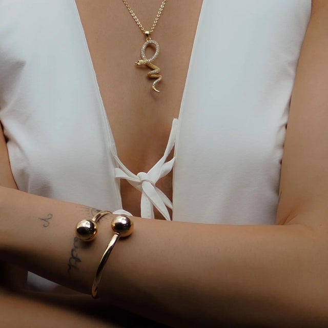 Dual Orb Gold Cuff Bracelet is a sleek and elegant accessory that adds a touch of sophistication to any look. Crafted with...