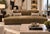 A contemporary three-seater sofa upholstered in a suede leather, featuring deep bench seating and sleek, low-profile...