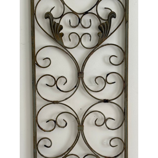 Vintage wrought iron wall panel featuring hand-formed scrollwork, cast leaf accents, and a rectangular frame with arched...