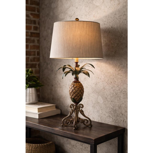 A stately late 20th century solid metal pineapple table lamp featuring a sculptural scroll base, dimensional carved body,...