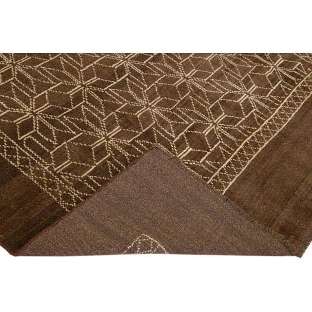 This Beautiful Moroccan-style handmade wool rug makes part of our Northwest collection and features a brown color field...
