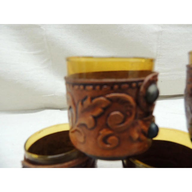Vintage six (6) hand blown shot glasses with embossed leather bands and metal tacks with embossed leather bands and metal...