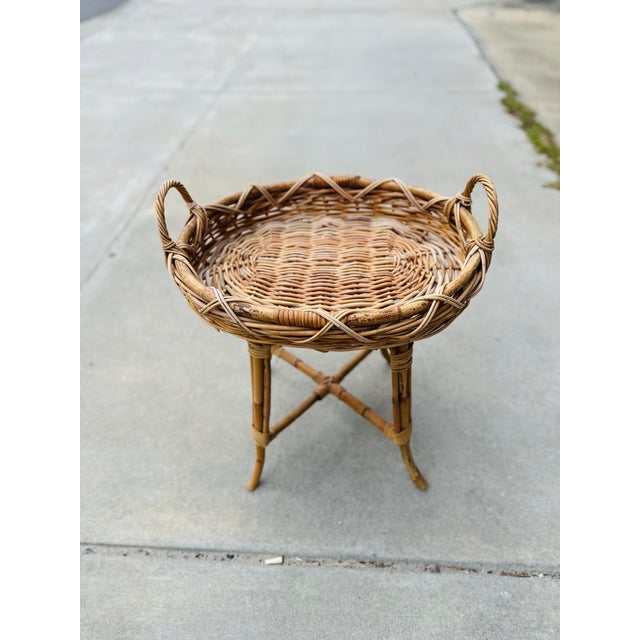 This is a vintage rattan and wicker side table with a beautifully woven tray-style top. The round tabletop features an...