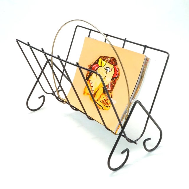 Mid Century Modern bent black metal wire magazine rack with brass plated circular handle