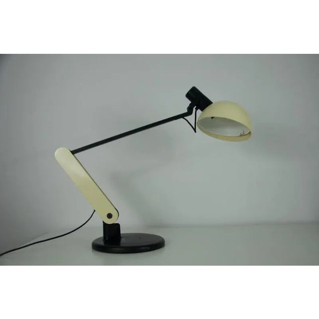 This is the iconic “praxi” table lamp designed by bruno gecchelin for guzzini, italy, in 1982. A hallmark of 1980s italian...