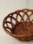 Hand-woven rattan basket with organic curved architecture. Tight weave base transitions to dramatic arching elements...