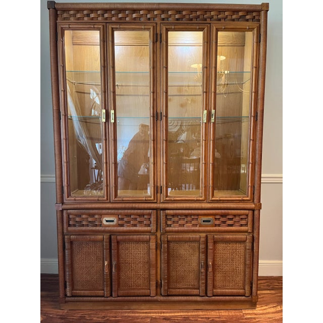Beautiful display cabinet by Dixie. There are 4 solid doors along the bottom with rattan wrapped edges and cane fronts....