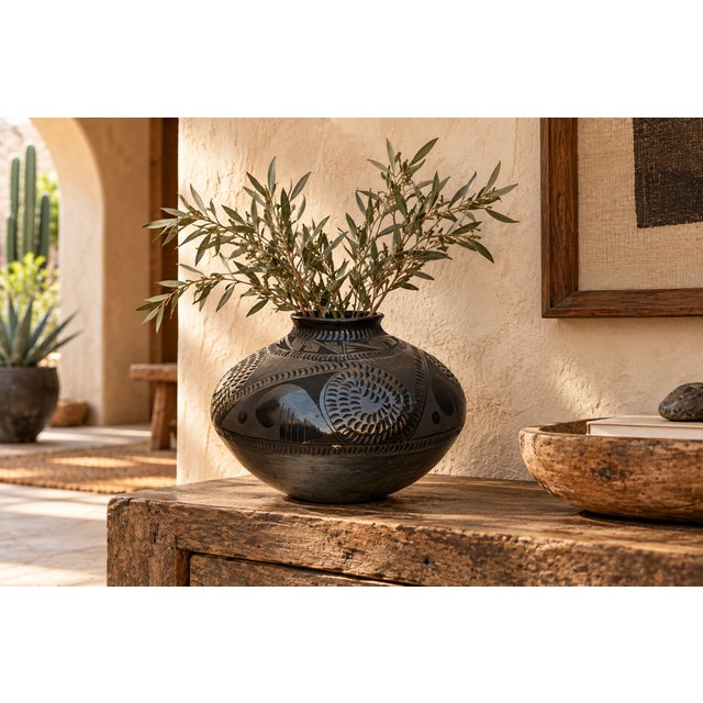 A broad, full-shouldered black pottery olla signed on the base Reynalda Quezada de Lopez of Mata Ortiz, Chihuahua, Mexico....