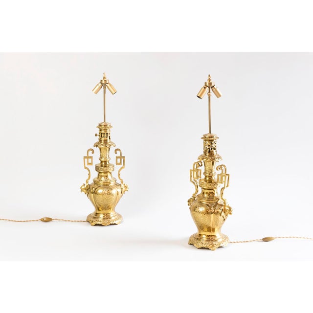 Pair of Arabian style lamps in chiselled and gilt brass bronze with a baluster shape standing on a circular quadruped...