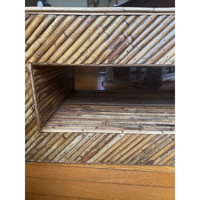 Fun mid-century split reed rattan coffee table. Oval shape with rectangle cut out for storage beneath. Burnt bent reeds...