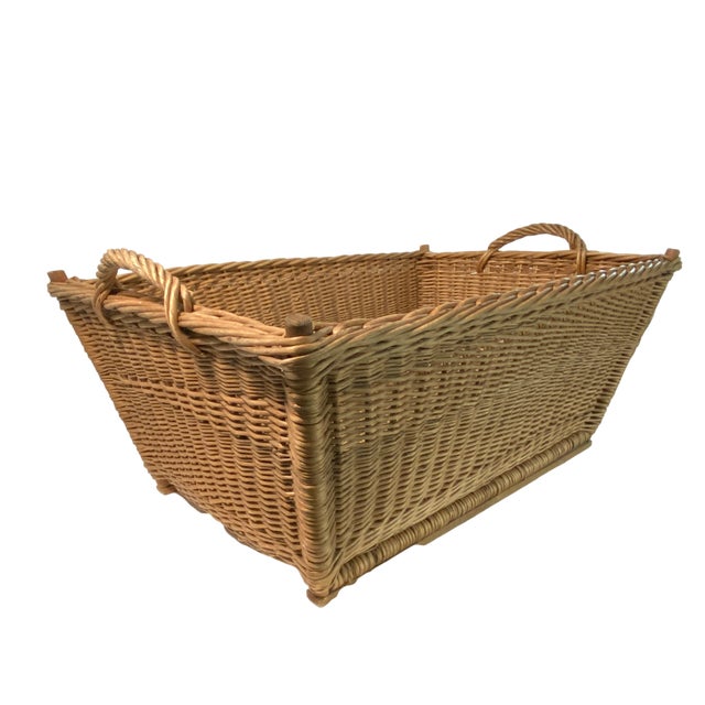 Extra large 1960s woven wicker French market basket with handles and braided trim. Two wood supports extend the length of...