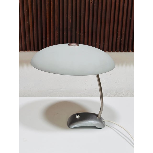 An elegant, functional table lamp from Germany, created in the early 1950s. The broad, domed metal shade, the gently...