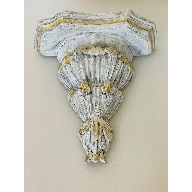 Vintage carved wood distressed wall bracket with touches of gold.