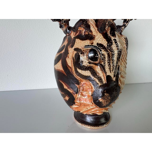 A striking and expressive 1980s vintage sculptural pottery vase in the style of African folk art. This organic handmade...