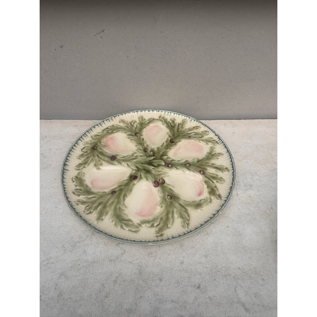French Majolica oyster plate signed Hippolyte Boulenger Choisy-le-Roi. The six pink wells are surrounded by green seaweeds.