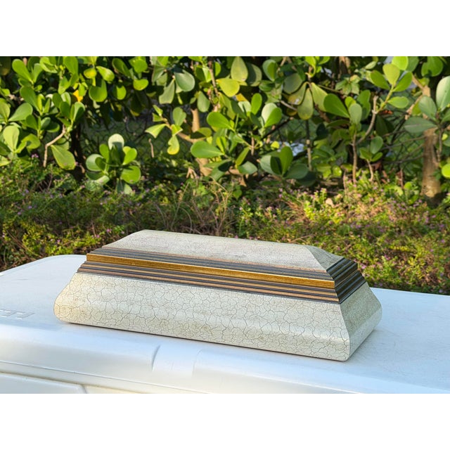 Vintage decorative box with a distinctive parchment-style covering in an intentionally crackled, aged finish. The stepped...