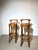 A elegant pair of vintage bar stools combining warm solid wood construction with tan leather upholstery and a brass-toned...