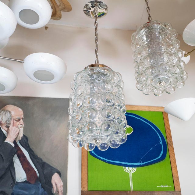 Clear bubble glass pendant with metal mesh diffuser.